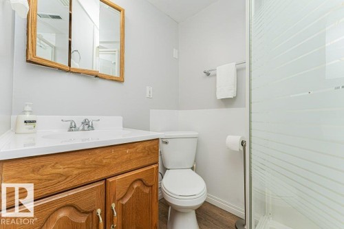 Vanity with wood-finish cabinetry, white countertop, and integrated sink - 6 Kiniski Crescent Nw, Edmonton, AB 