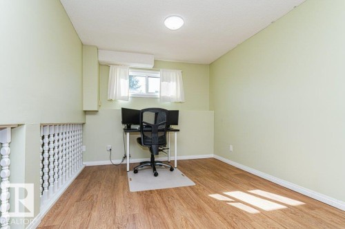 Wood-finish flooring, light green painted walls, white ceiling, window with white curtains, and a white spindle railing - 6 Kiniski Crescent Nw, Edmonton, AB 