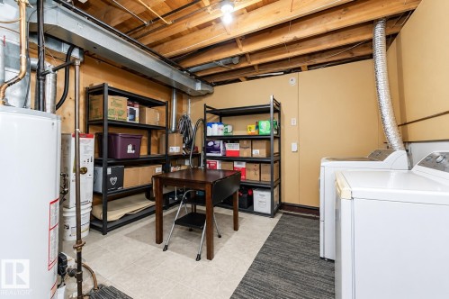 Utility space featuring exposed ceiling joists, hard surface flooring, and a water heater - 6 Kiniski Crescent Nw, Edmonton, AB 