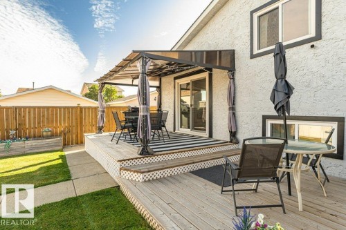 Expansive wood-finish deck with a covered pergola, providing an outdoor living area - 6 Kiniski Crescent Nw, Edmonton, AB 