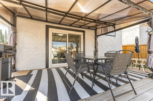 Covered outdoor deck with a clear panel roof and wood-finish decking - 6 Kiniski Crescent Nw, Edmonton, AB 
