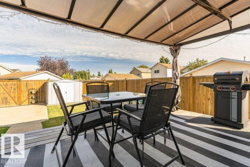 Deck featuring a gazebo with a translucent roof, a wood privacy fence, a concrete patio, and a storage shed - 6 Kiniski Crescent Nw, Edmonton, AB 