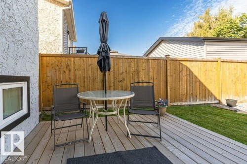 Outdoor wood-finish deck with a wood privacy fence and a patch of grass - 6 Kiniski Crescent Nw, Edmonton, AB 