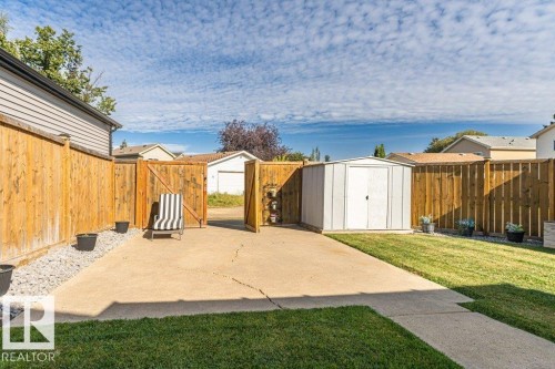 Manicured lawn, full wood fencing, concrete patio, gravel border, and a functional storage shed - 6 Kiniski Crescent Nw, Edmonton, AB 