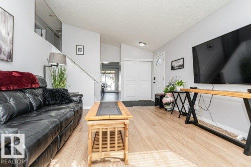 Hardwood-finish flooring, vaulted ceilings, and a front entry door with decorative glass - 6 Kiniski Crescent Nw, Edmonton, AB 