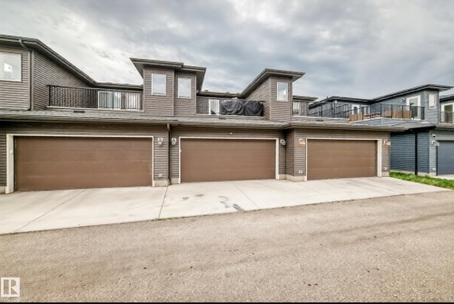 Modern multi-level townhome exterior featuring horizontal siding and multiple private balconies with black metal railings - 19716 27 Avenue Nw, Edmonton, AB - Outdoor