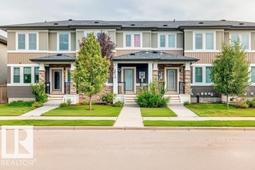 Contemporary multi-level townhome featuring a stone and siding facade, covered entry, and individual sidewalks - 19716 27 Avenue Nw, Edmonton, AB - Outdoor With Facade