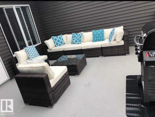 Exterior patio featuring a textured floor and dark horizontal siding - 19716 27 Avenue Nw, Edmonton, AB - Outdoor With Exterior