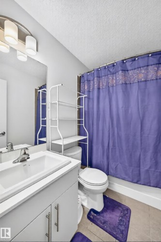 Bathroom featuring a single vanity with an integrated sink, white cabinetry, and a chrome faucet - 19716 27 Avenue Nw, Edmonton, AB - Indoor Photo Showing Bathroom