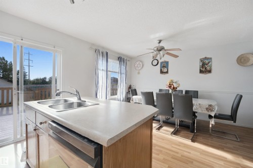 Kitchen island with a double basin stainless steel sink and integrated dishwasher - 15911 38 Street Nw, Edmonton, AB 