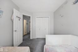 Bedroom featuring carpet flooring, white paneled doors, and bi-fold closet doors - 