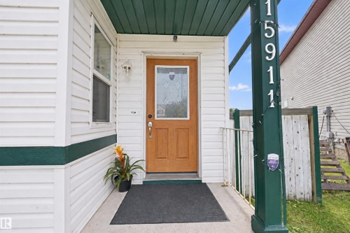White vinyl siding exterior with dark green trim - 15911 38 Street Nw, Edmonton, AB 