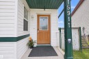 White vinyl siding exterior with dark green trim - 15911 38 Street Nw, Edmonton, AB 
