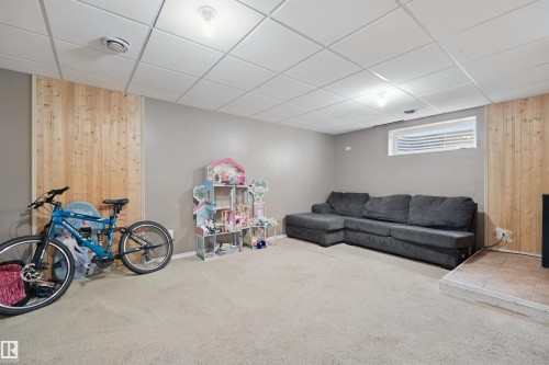 Recessed lighting, drop ceiling, horizontal window, carpet flooring, and wood-paneled wall accents - 15911 38 Street Nw, Edmonton, AB 
