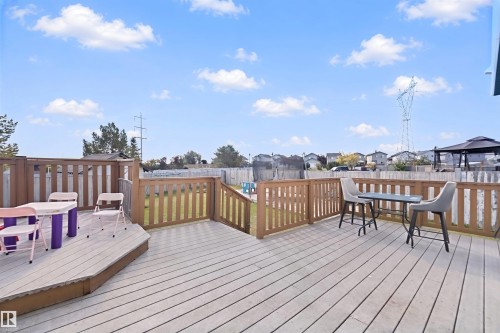 Expansive backyard deck with wood-finish flooring and full perimeter fencing - 15911 38 Street Nw, Edmonton, AB 