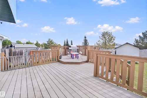Multi-level wood deck with wood railings, featuring a raised octagonal platform - 15911 38 Street Nw, Edmonton, AB 