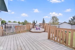 Multi-level wood deck with wood railings, featuring a raised octagonal platform - 
