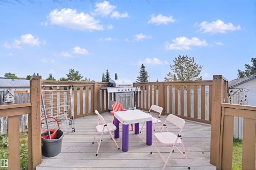Wood-finish deck with a perimeter railing and slatted fencing - 15911 38 Street Nw, Edmonton, AB 