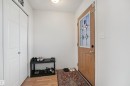 Wood-finish flooring, light wood entry door with decorative glass insert, and a flush-mount ceiling light fixture - 15911 38 Street Nw, Edmonton, AB 