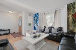 Wood-finish flooring throughout, framed window with roller blind, recessed lighting, and a light wood-tone entry door with decorative glass inserts - 