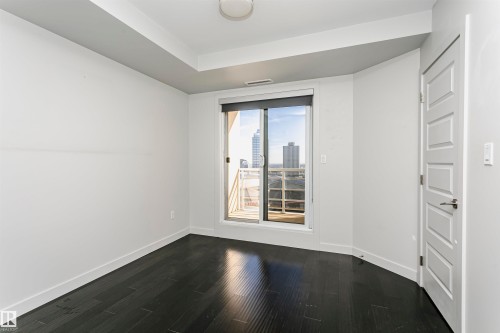 Wood-finish flooring, sliding glass door with balcony access, recessed ceiling, and panel door - #1902 10388 105 St Nw, Edmonton, AB 