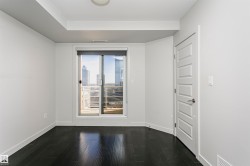 Dark wood-finish flooring, white walls, and a five-panel interior door - 