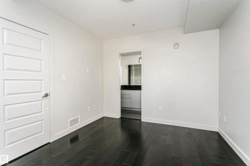 Dark wood-finish flooring with white baseboards and neutral wall tones - #1902 10388 105 St Nw, Edmonton, AB 