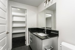 Modern vanity with a rectangular undermount sink, dark stone countertop, and contemporary faucet - 