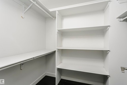 Built-in shelving, multiple hanging rods, and dark wood-finish flooring - #1902 10388 105 St Nw, Edmonton, AB 
