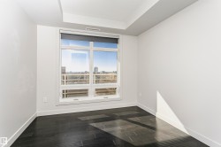 Large window offering city scenery, recessed ceiling detail, dark wood-finish flooring, and light-toned walls - 