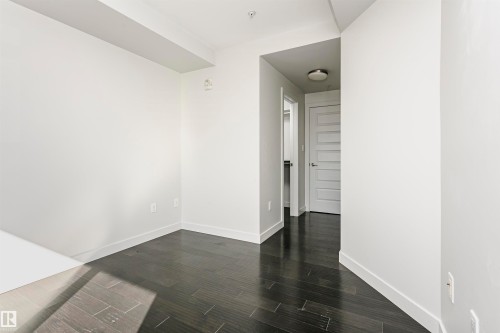Dark wood-finish flooring, white walls, recessed ceiling lighting, and a five-panel interior door - #1902 10388 105 St Nw, Edmonton, AB 