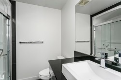 Contemporary bathroom featuring a dark countertop, integrated rectangular basin, and chrome faucet - 