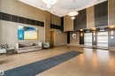 Lobby featuring large format floor tiling, recessed lighting, accent wall paneling, and dual elevators with stainless steel doors - #1902 10388 105 St Nw, Edmonton, AB 