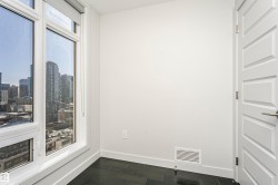 Floor-to-ceiling windows, dark wood-finish flooring, white walls, white paneled door, and brushed nickel hardware - 