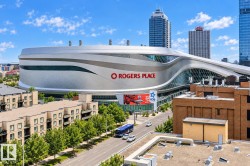 Rogers Place arena, commercial buildings, residential structures with balconies, urban street, and established street trees - 