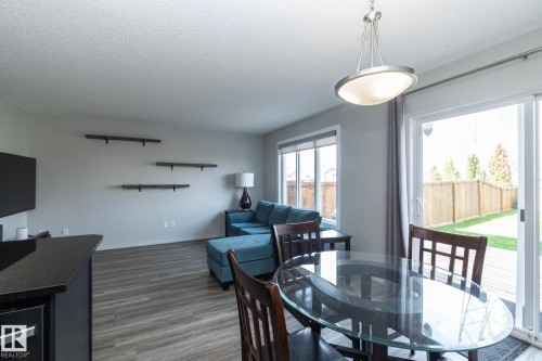 Open-concept living space with wood-finish flooring, recessed lighting, and large windows - 1640 Chapman Way Sw, Edmonton, AB - Indoor Photo Showing Dining Room