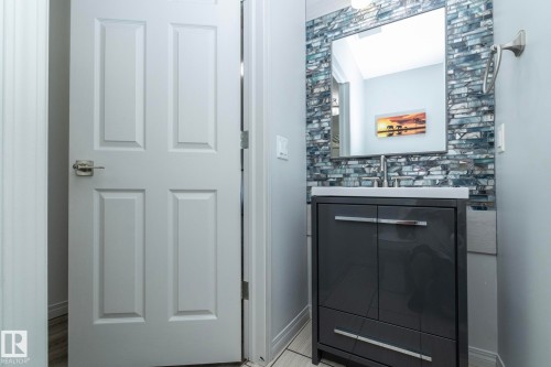 Vanity featuring a tiled backsplash, integrated sink, and modern cabinetry - 1640 Chapman Way Sw, Edmonton, AB - Indoor