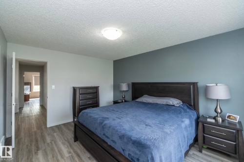 Bedroom featuring wood-finish flooring and a neutral color palette with an accent wall - 1640 Chapman Way Sw, Edmonton, AB - Indoor Photo Showing Bedroom