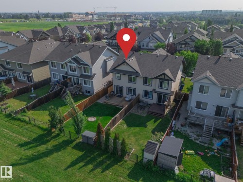 Rear exterior featuring a multi-level deck, fenced yard with green space, and lower level patio - 1640 Chapman Way Sw, Edmonton, AB - 