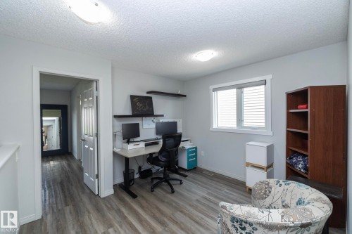 Room featuring wood-finish flooring, a window with blinds, light gray wall paint, and white trim - 1640 Chapman Way Sw, Edmonton, AB - Indoor Photo Showing Office