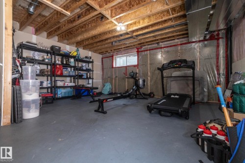 Unfinished basement space with exposed wood joists, concrete flooring, and a single window - 1640 Chapman Way Sw, Edmonton, AB - Indoor Photo Showing Basement