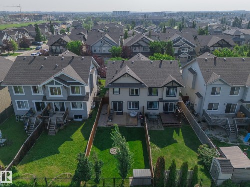Expansive residential backyard featuring a manicured lawn, established trees, and a wooden deck - 1640 Chapman Way Sw, Edmonton, AB - Outdoor With Facade