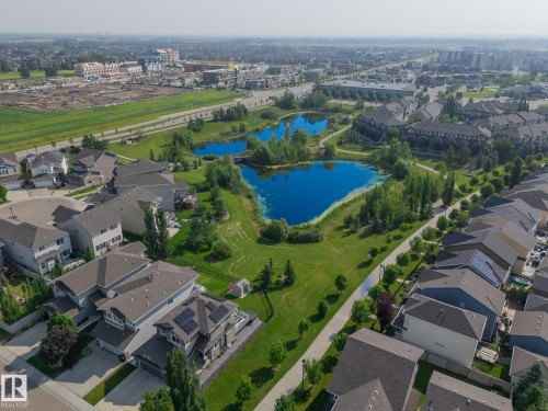 Aerial panorama showcasing residential properties alongside a central green space featuring multiple ponds and established trees - 1640 Chapman Way Sw, Edmonton, AB - Outdoor With View