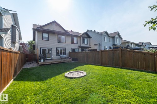 Manicured lawn with a built-in fire pit, surrounded by a wood privacy fence - 1640 Chapman Way Sw, Edmonton, AB - Outdoor