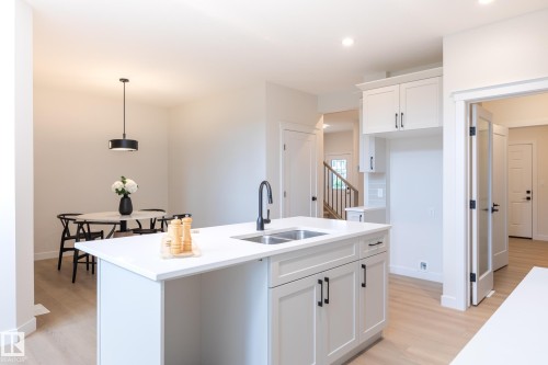 Kitchen island with dual sinks and a matte black faucet - 6306 65 Ave, Beaumont, AB 