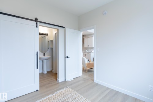 Light wood-finish flooring throughout, with white interior doors and white baseboards - 6306 65 Ave, Beaumont, AB 