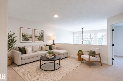 Carpeted common area featuring a half-wall partition, recessed lighting, and a series of three windows - 6306 65 Ave, Beaumont, AB 