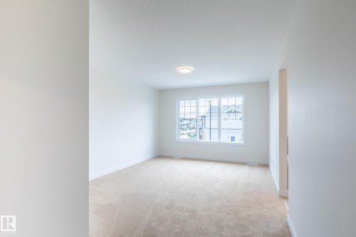 Neutral wall paint, plush carpeting, multi-pane window, and flush mount lighting - 6306 65 Ave, Beaumont, AB 