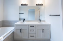 Dual vanity with white countertop, undermount sinks, and matte black fixtures - 