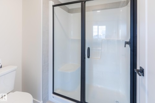 Walk-in shower with clear glass enclosure and matte black framing - 6306 65 Ave, Beaumont, AB 